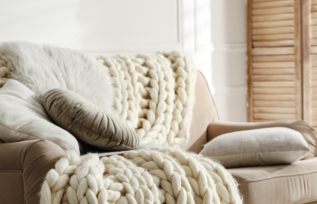 Gemütliche Couch mit Decke und Kissen